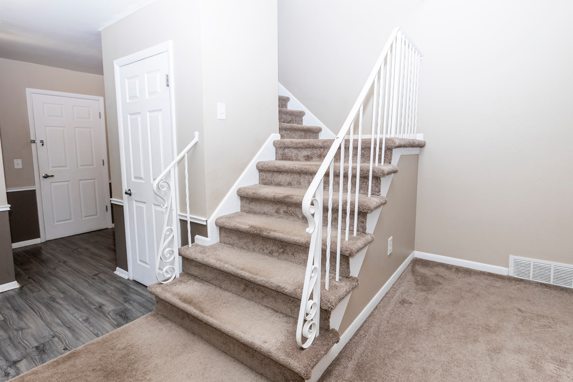 Main staircase with carpeted treads and white railing