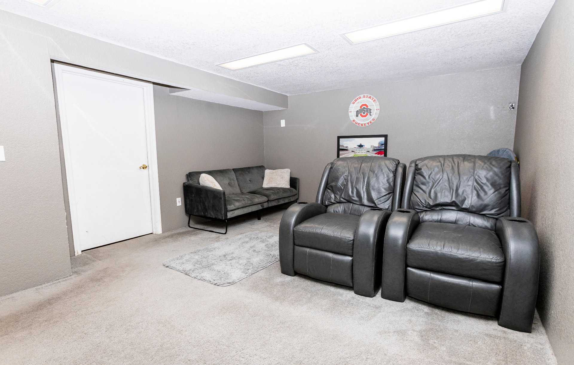 Media room with dual recliners, lounge sofa, and plush carpeting