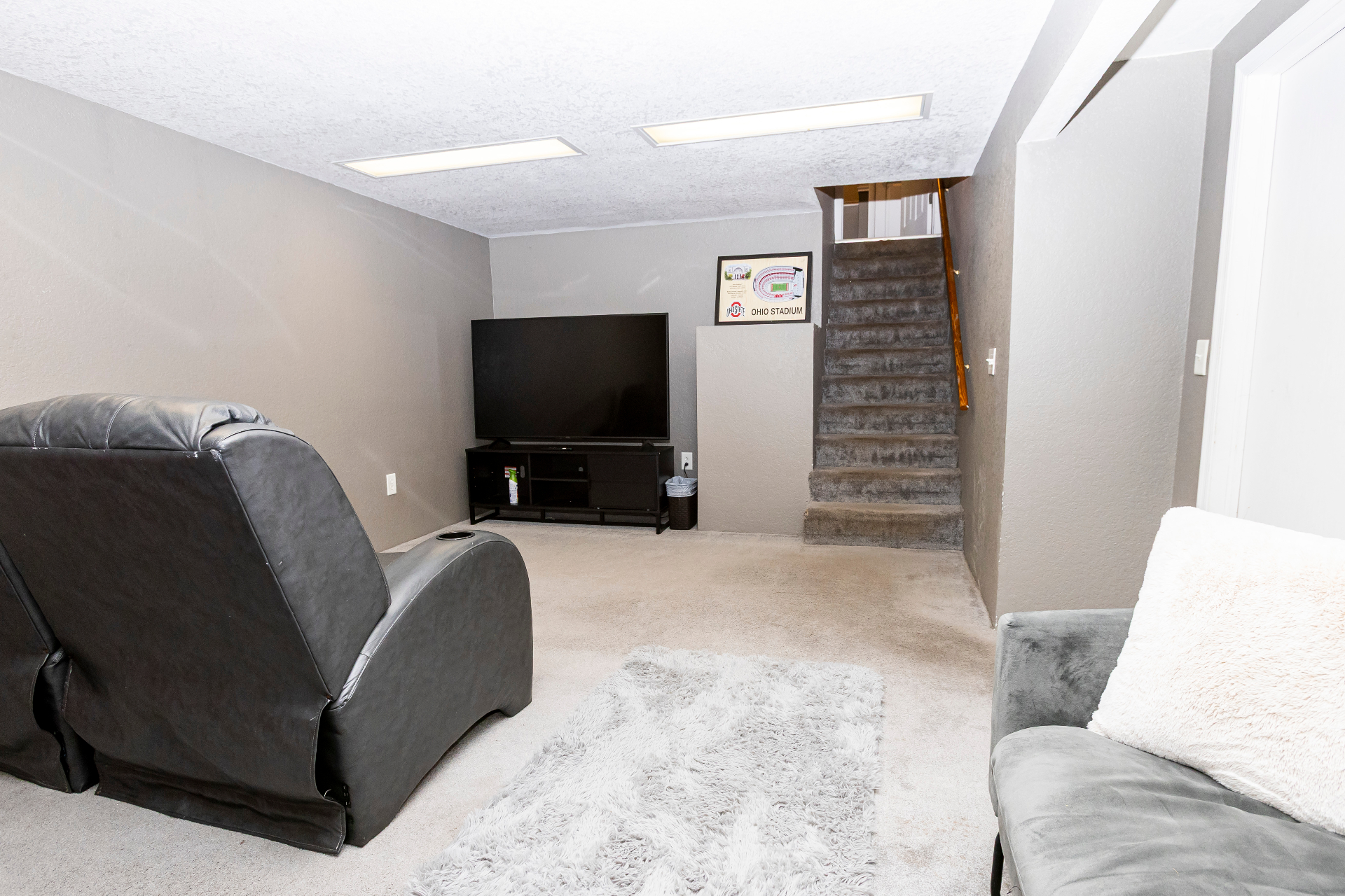 Second lower-level media room with reclining theater chairs and large TV
