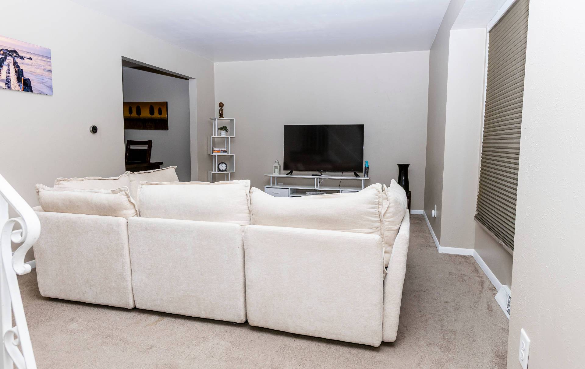 Living lounge with sectional facing the smart TV and media shelving