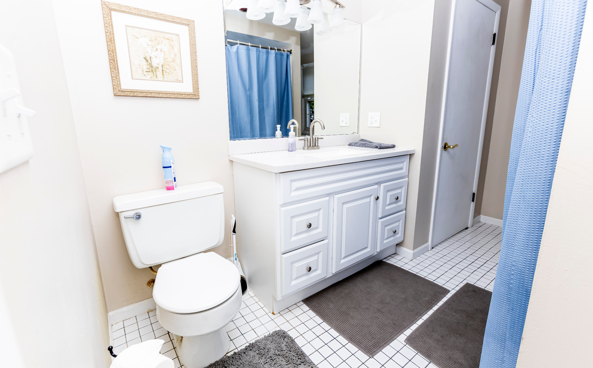 Full bathroom with white vanity, tiled floor, and tub/shower