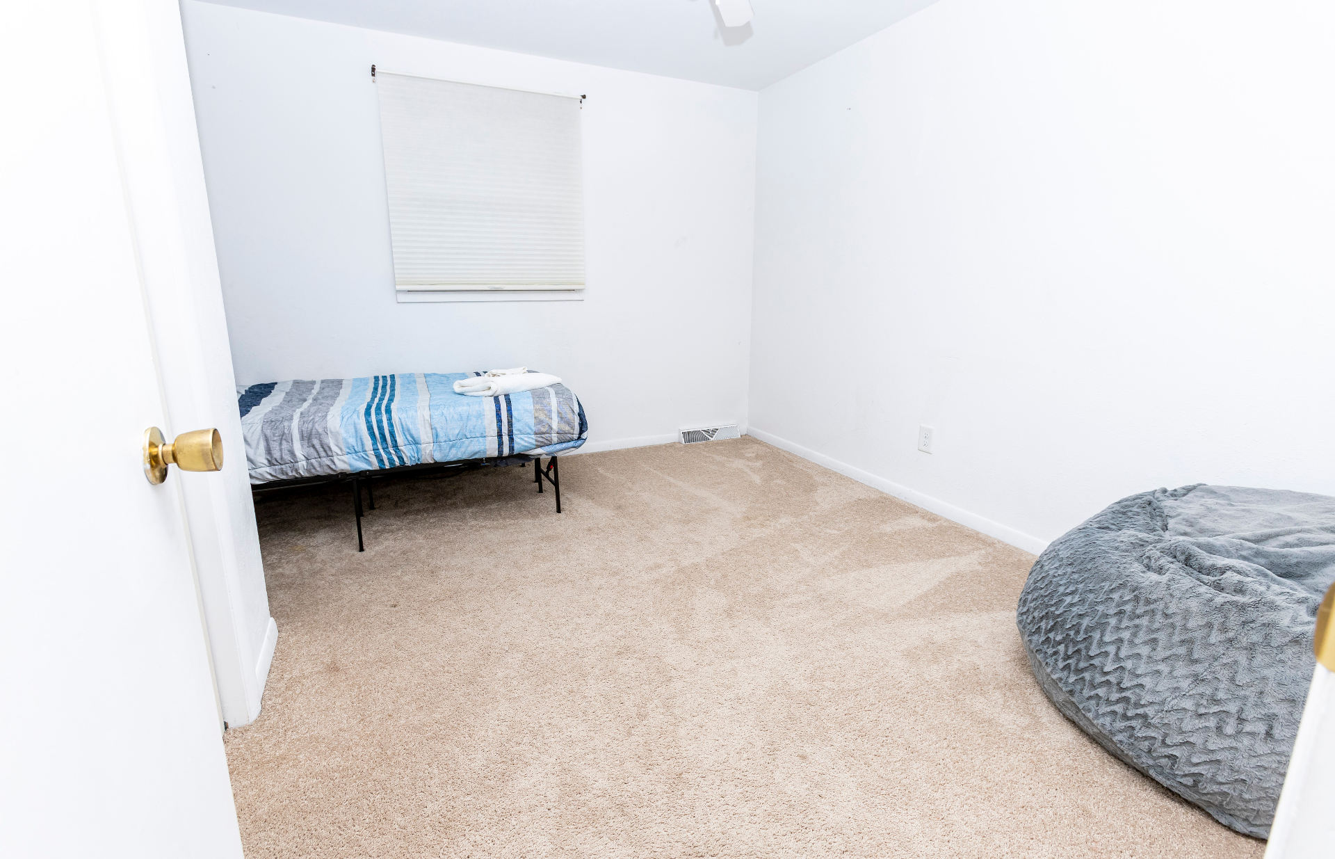 Flex bedroom with a twin bed, bean bag chair, and open floor space